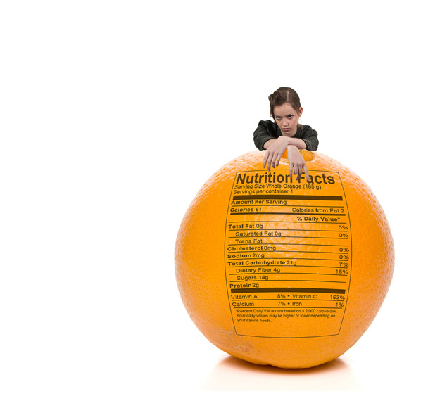 オレンジ色の栄養物のラベルの後ろに立っている 10 代女性 - 写真・画像