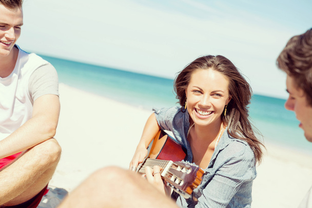 Beautiful young woman playing guitar on beach - Photo, Image