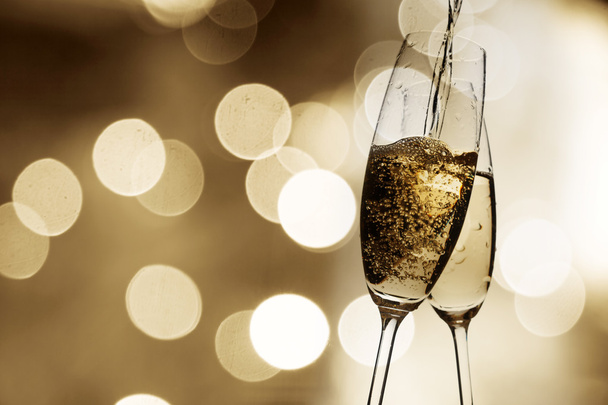 Brindar com taças de champanhe contra luzes de férias
 - Foto, Imagem