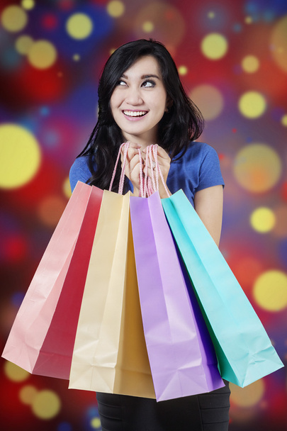 Excited shopper holds christmas shopping bags - Фото, изображение