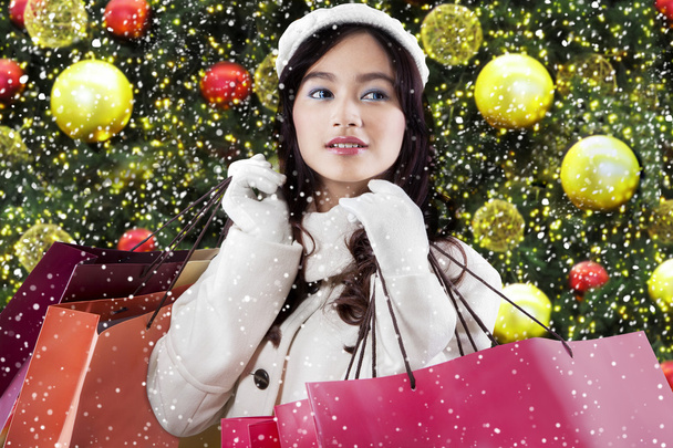 Girl holds shopping bags with christmas decoration - Photo, image
