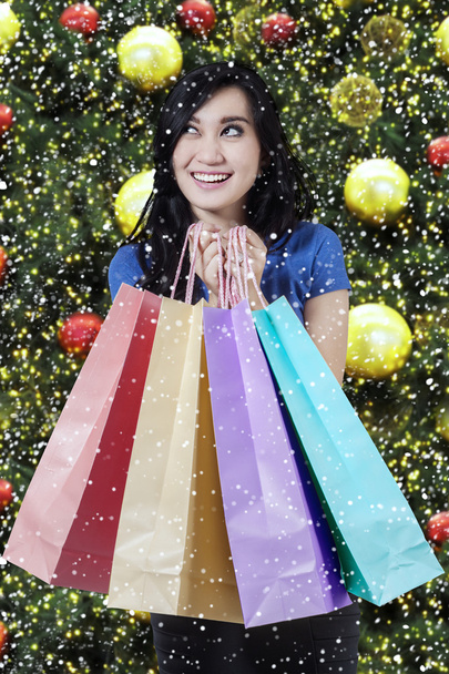 Joyful shopper holds christmas shopping bags - Foto, afbeelding