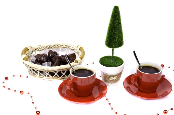 Two red cups of coffee tree and a basket of chocolate. - Photo, Image