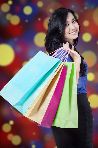 Shopper holds shopping bags with defocused background - Фото, зображення
