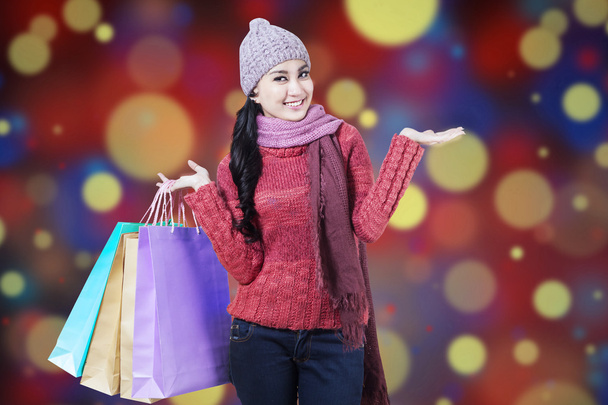 Woman with shopping bags and bokeh background - Photo, image