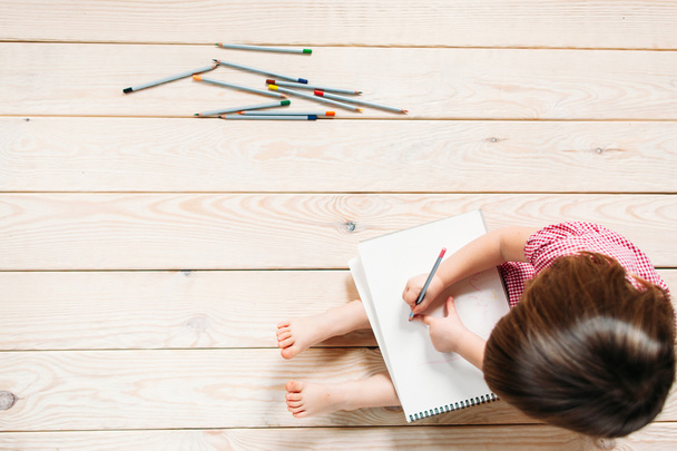 little girl drawing with colorful pencils - Fotó, kép