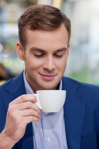 Attractive businessman is enjoying coffee at restaurant - Фото, зображення