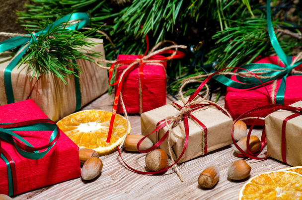 Boxes with gifts and hazelnuts under the Christmas tree - Photo, Image