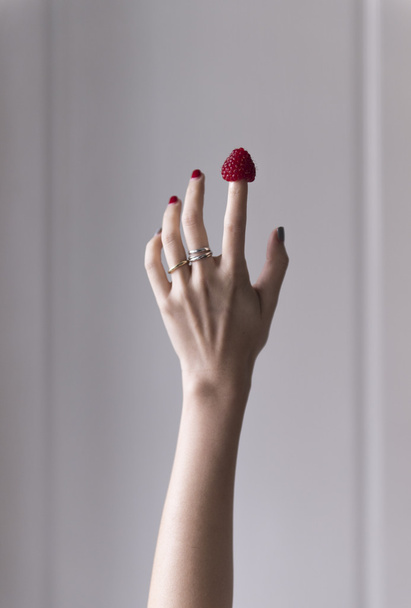 A hand holding a raspberry - Zdjęcie, obraz