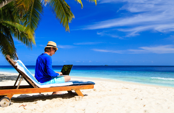 Mann mit Laptop am tropischen Strand - Foto, Bild