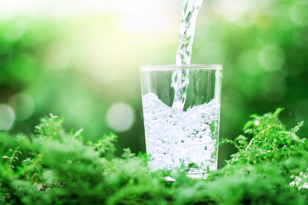 стакан прохладной пресной воды на зеленом фоне
 - Фото, изображение