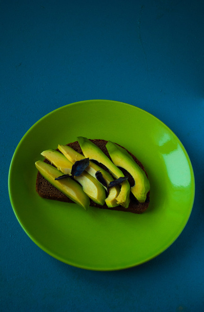 Avocado-Sandwich auf dunklem Roggenbrot - Foto, Bild