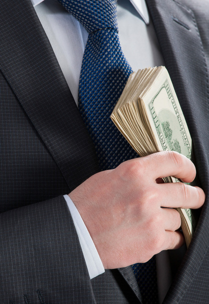  Businessman putting money in his pocket - Foto, Bild