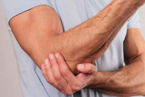 Man With Pain In Elbow. Pain relief concept - Foto, afbeelding