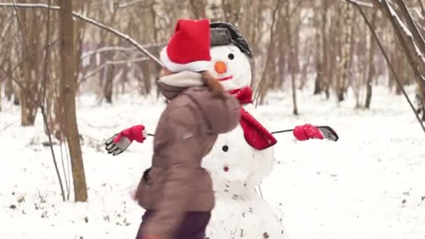 Ten year-old girl going around a snowman - Footage, Video