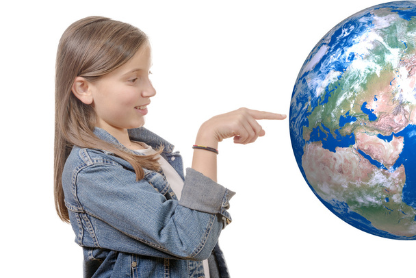 Portrait of a smiling little girl pointing finger on world globe - Foto, Imagen