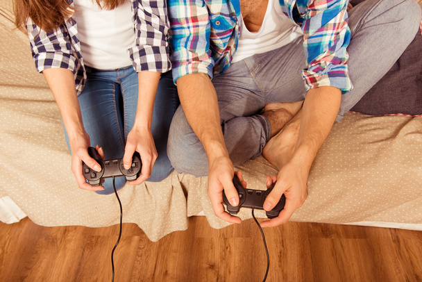 at home woman and man in love playing video games joysticks - Photo, image