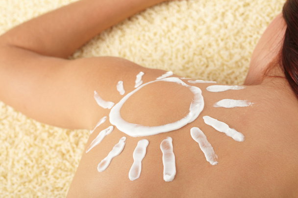 Woman with sun-shaped sun cream - Photo, Image