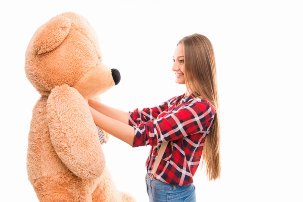 Lovely pretty girl holding big teddy bear in put out hands  - Fotó, kép