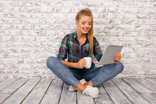 Cheerful cute girl with tablet and cup - Foto, afbeelding