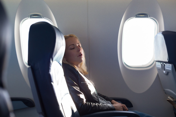 Lady traveling napping on a plain. - Photo, Image
