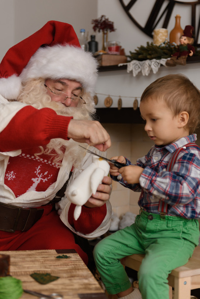 Santa Claus with Child sewing together - Фото, изображение