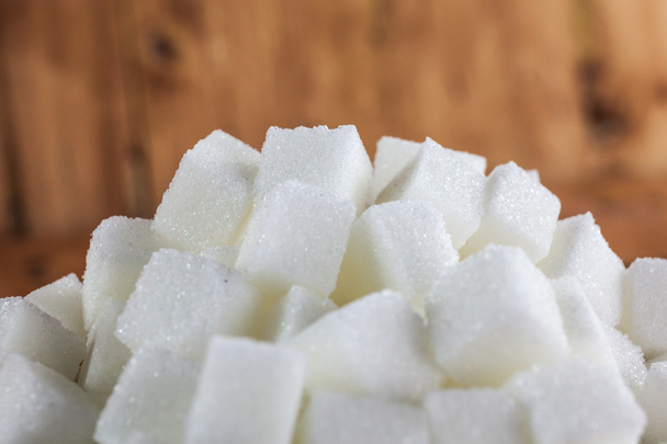 Pile of Sugar Cubes over Wooden Background - Photo, Image