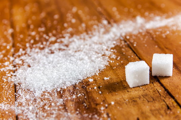 Granulato bianco zucchero fuoriuscita su sfondo di legno
 - Foto, immagini