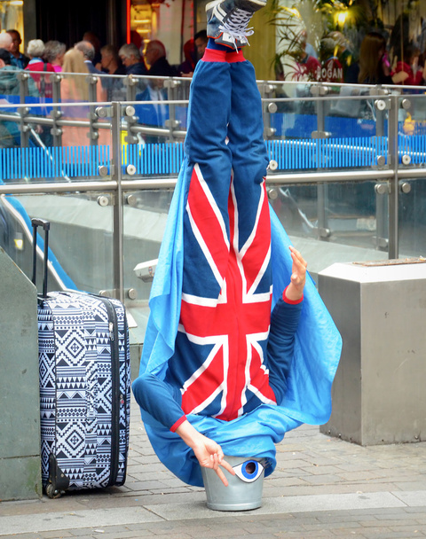 Wykonawca londyńskiej ulicy stoi na głowie w wiadrze - Zdjęcie, obraz
