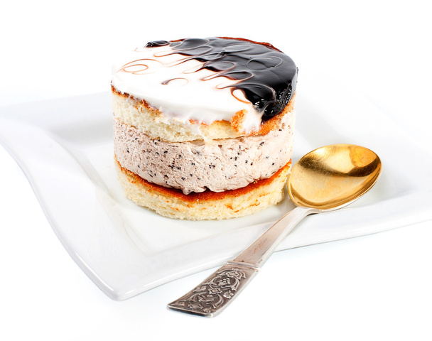 Десертний крем торт на тарілці з ложкою
 - Фото, зображення
