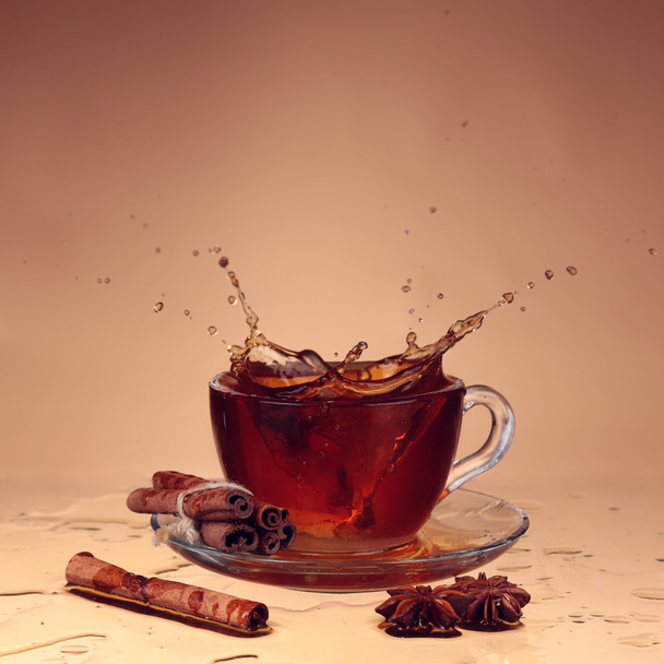 kopje thee op glas met oranje achtergrond - Foto, afbeelding