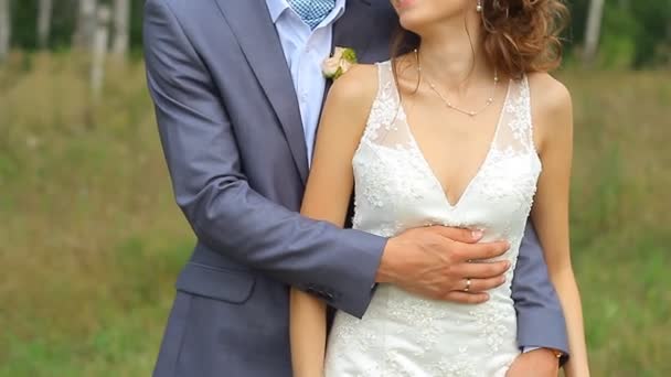 Szép esküvő házaspár a zöld mezőben sétál - Felvétel, videó