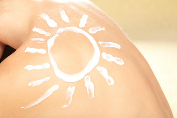 Woman with sun-shaped sun cream - Foto, imagen