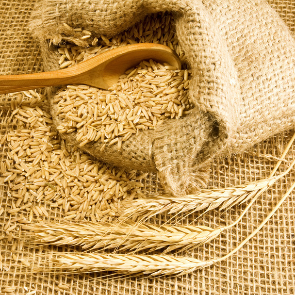 wheat in sack and spikelets on the table - Photo, Image