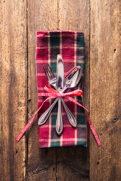 Cutlery on checkered napkin with ribbon branch on wooden background - Fotoğraf, Görsel