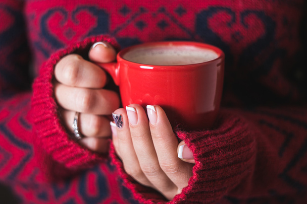 La chica en el suéter rojo sosteniendo una taza de café rojo
 - Foto, Imagen