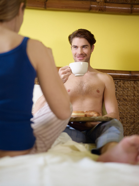 Jeune couple prenant le petit déjeuner au lit - Photo, image