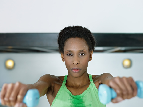 African woman exercising with small weights in gym - Photo, Image