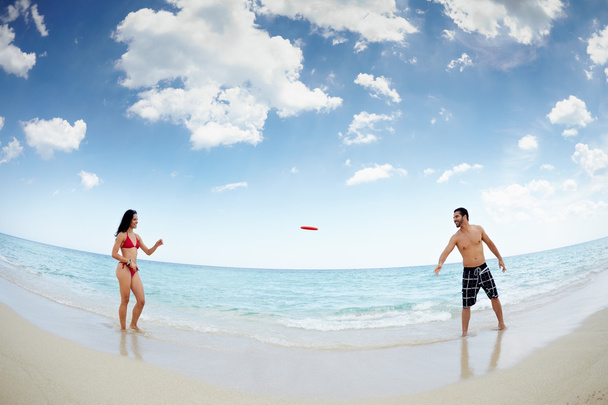 Jovem homem feliz e mulher brincando com frisbee
 - Foto, Imagem