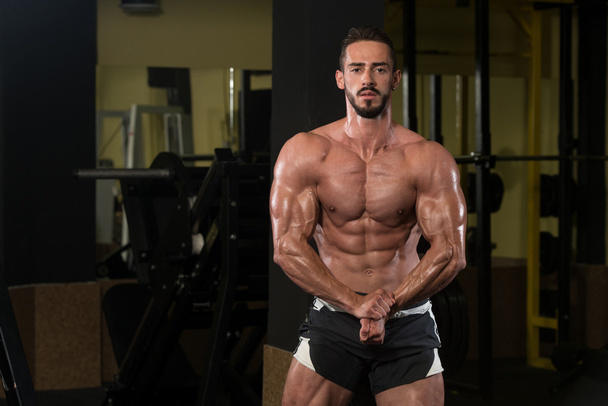 Handsome Body Builder Making Most Muscular Pose - Foto, afbeelding