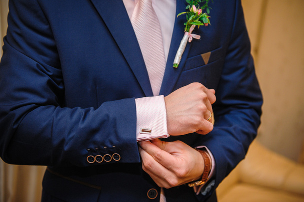groom in a suit hands wear cufflinks in room - Photo, Image