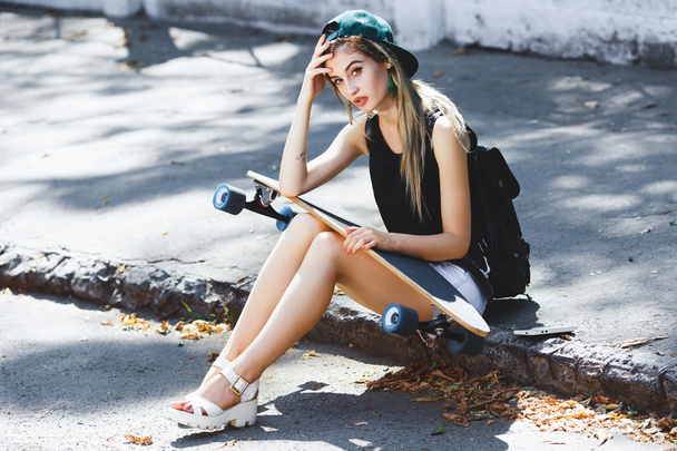 Cheerful girl sitting on the pavement - Fotó, kép
