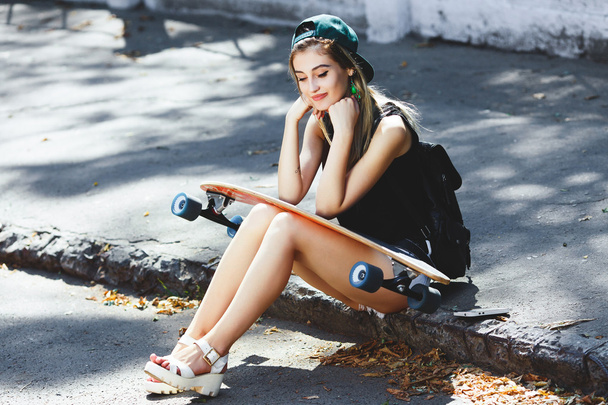 Cheerful girl sitting on the pavement - Zdjęcie, obraz