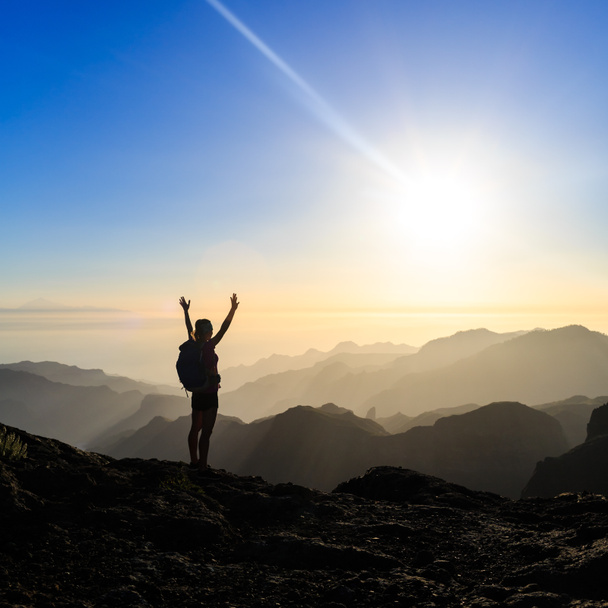 Mujer senderismo éxito silueta en las montañas puesta del sol
 - Foto, imagen
