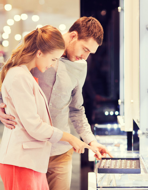 happy couple choosing engagement ring in mall - Foto, imagen
