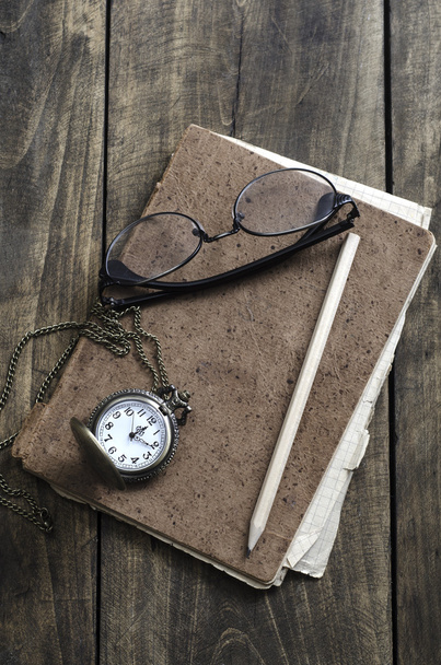 Pocket watch, glasses and old notebook on table - Foto, imagen