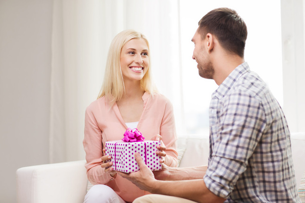 happy man giving woman gift box at home - Foto, Imagen