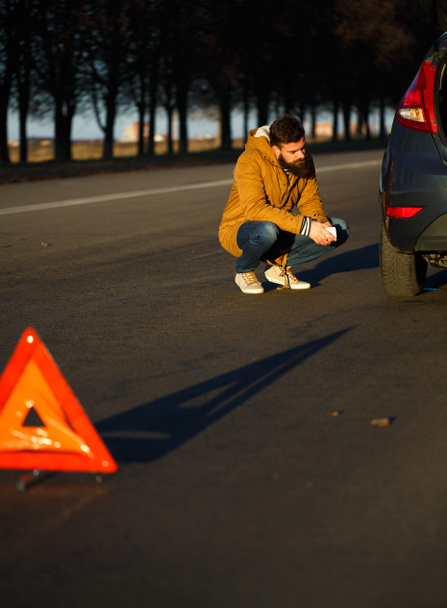 Motorista examinando automóveis danificados
 - Foto, Imagem