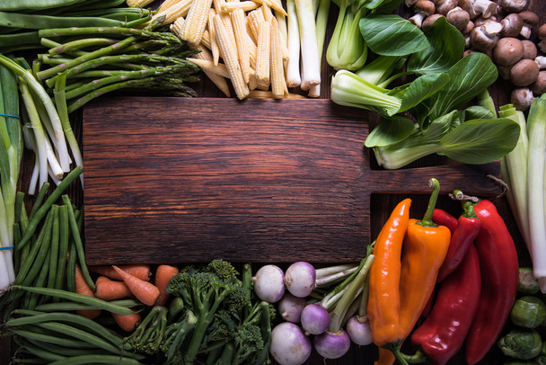 Φρέσκα λαχανικά και άδειο cutting board, φόντο τροφίμων με αντίγραφο χώρου - Φωτογραφία, εικόνα