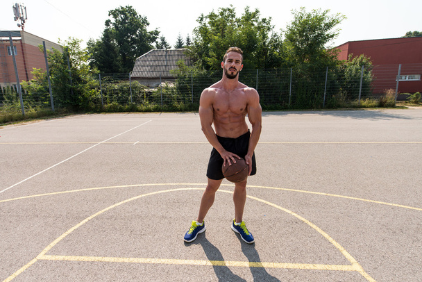 Bodybuilder Playing Basketball Outdoor - Foto, immagini